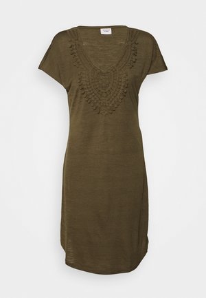 Olijfgroene jurk van lichtgewicht stof, met een V-hals en een ingewikkeld textuurontwerp met kwastaccenten. Korte mouwen.