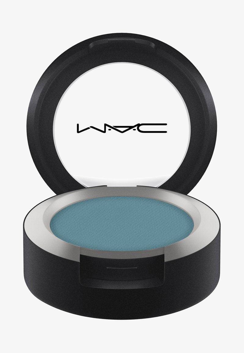 Okrągły, kompaktowy cień do powiek w czarnej obudowie. Posiada teksturowany turkusowy proszek z srebrną obręczą. Otwarta pokrywka wyświetla logo marki wewnątrz.