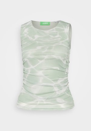 Mouwloos lichtgroen topje met wit abstract patroon van watergolven en geplooide zijkanten, gebrandmerkt JJXX op een groen label aan de binnenkant van de halslijn.
