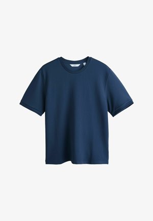 Laivastonsininen lyhythihainen, pyöreäkauluksinen teksturoitu T-paita, jossa suora helma ja pieni kangasmerkki kauluksen sisäpuolella.