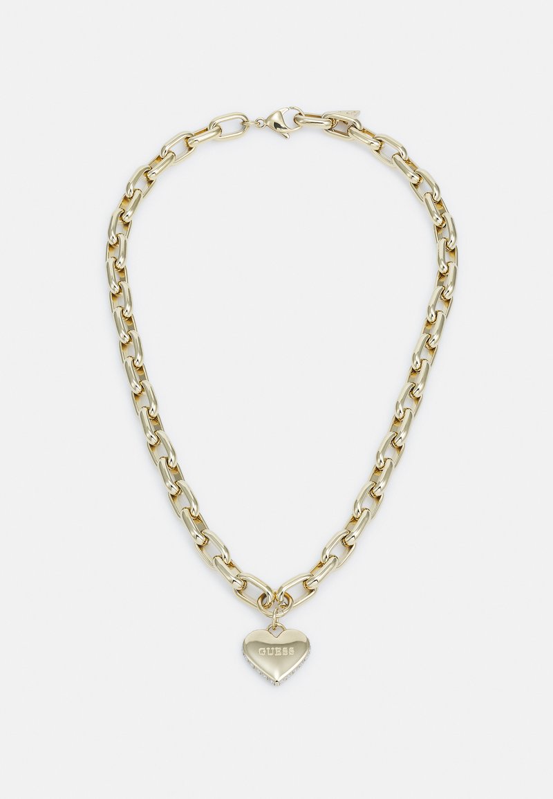 Colar de corrente em tom de ouro com elos ovais, apresentando um pingente em forma de coração gravado com "GUESS" e adornado com pequenos detalhes.
