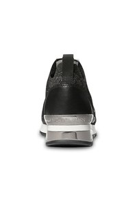 Scarpa da ginnastica nera con tomaia strutturata, retro imbottito e dettagli riflettenti argentati su tallone e suola. Logo visibile sul tallone.