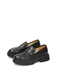 Black leather loafers with a rounded toe and a chunky rubber sole. Features a flat platform and a simple strap across the vamp.