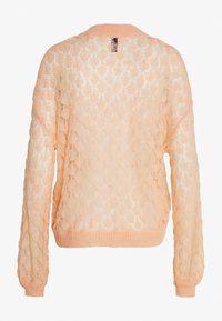 Lichtgewicht, perzikkleurige gebreide trui met een diamantpatroon, lange mouwen en een geribde kraag en zoom. Opengeweven textuur.