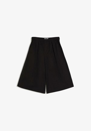 Zwarte shorts met wijde pijpen, een elastische tailleband en zijzakken, plat uitgestald op een witte achtergrond.