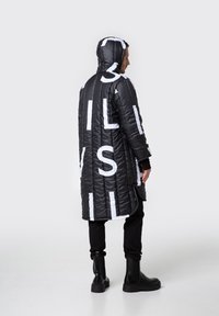Pikowana czarna długa kurtka z kapturem, wyraźnym białym napisem i fakturowanym materiałem. Posiada boczne kieszenie i luźny krój.