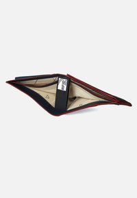 Portafoglio in pelle blu navy con accenti rossi, dotato di un comparto sicuro per RFID. Design slim, forma piegata e interno beige con un motivo geometrico.
