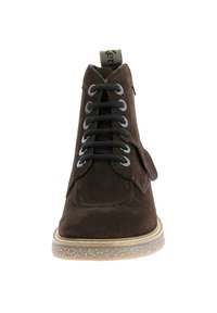 Botín de ante marrón con cordones negros, puntera redonda y suela de goma texturizada. Presenta una solapa lateral con un detalle de costura.