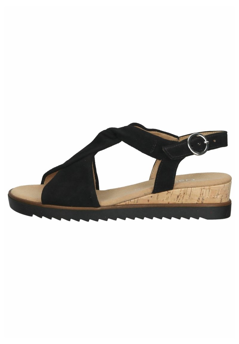 Sandale en cuir suédé noir avec des sangles croisées, une bride de cheville réglable, un talon en liège et une semelle en caoutchouc texturé pour une meilleure adhérence.
