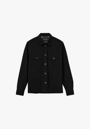 Cămașă neagră cu nasturi, cu mâneci lungi, două buzunare pe piept și guler ascuțit. Confecționată dintr-un material neted cu un finisaj mat.