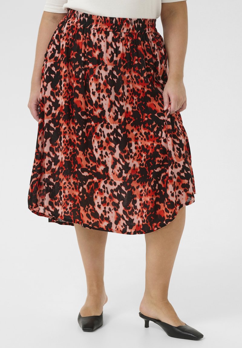 Jupe imprimée léopard rouge et noire avec une taille élastique, longueur genoux, fabriquée en tissu léger, présentant une silhouette fluide et plissée.