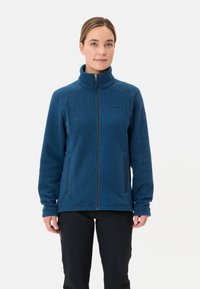 Giacca in fleece blu con zip frontale, colletto alto e due tasche laterali; presenta un tessuto testurizzato e una discreta personalizzazione sul lato sinistro del petto.