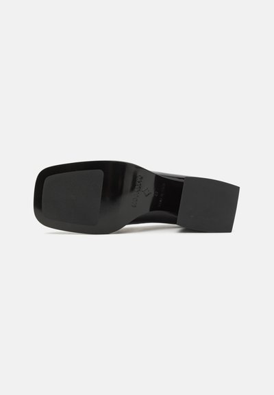 Black high heel shoe with a sleek, glossy upper, featuring a square toe and a sturdy block heel. The sole is textured for grip.
