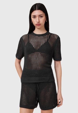 Set in maglia nera composto da pullover e pantaloni shorts, caratterizzato da un design a rete aperta e morbida, maniche corte, scollo tondo e polsini e orlo a coste.