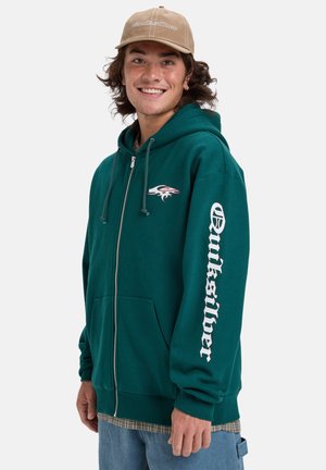 Teal hoodie met ritssluiting en een voorzak, met een wit logo op de linkerborst en grote tekst op de rechtermouw. Textuurstof.