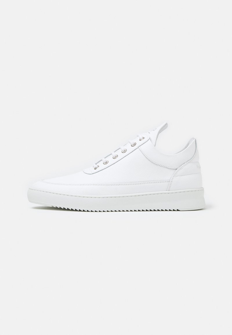 Zapatillas blancas con parte superior de cuero liso, puntera redondeada, seis ojales metálicos y suela de goma texturizada blanca. Diseño minimalista.