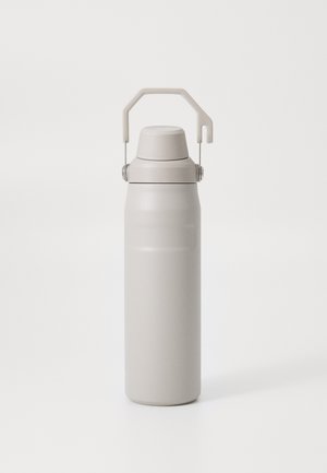 Garrafa de água isolada em aço inoxidável com acabamento mate bege, formato cilíndrico e uma alça dobrável para transporte.