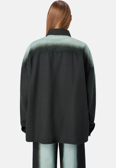 Mustapoyta denimpaita, jossa on vihreä gradienttikaulus, rento istuvuus ja pudotetut olkapäät. Ominaisuuksiin kuuluu sileä pinta ja nappihihat.