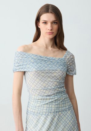Haut dénudé avec un motif à carreaux bleu clair et jaune, présentant une texture froncée et des manches courtes, fabriqué en tissu transparent et léger.