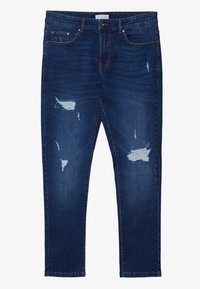 Jeans de mezclilla azul oscuro de corte ajustado, con acentos desgastados y parches deshilachados. Diseño clásico de cinco bolsillos con cierre de cremallera.