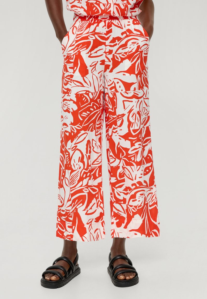 Czerwono-białe spodnie szerokie z lekkiego materiału w kwiatowe wzory, z bocznymi kieszeniami i elastycznym pasem.