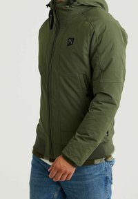 Olivově zelená zateplená bunda s předním zipem, kapucí, dvěma postranními kapsami a malou černou nášivkou na hrudi. Hladká textura.