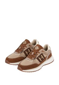 Sneakers in suede marrone e beige con suole bianche spesse, lacci marroni e logo "H" sui lati, angolati per mostrare le viste esterne e frontali.