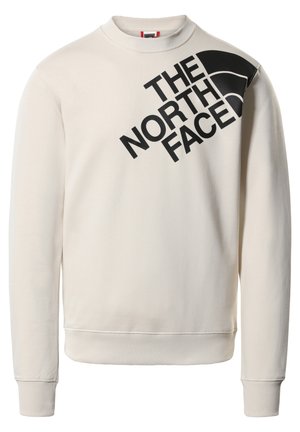 Kremfarvet sweatshirt med sort "The North Face" logo og grafik på den øverste venstre del af brystet og skulderen.