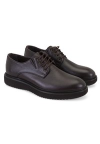 Chaussures en cuir marron avec une surface texturée, bout arrondi et lacets marron. Dotées d'une semelle noire épaisse avec un motif en relief pour une meilleure adhérence.