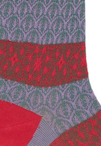 Colorful socks featuring a mix of textures and patterns: purple and green geometric designs with red and dark green striped sections.
