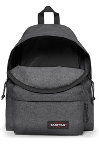 Mochila de tela gris con parte superior redondeada, correas de hombro ajustables, bolsillo frontal con cremallera y logotipo de Eastpak en la parte frontal.