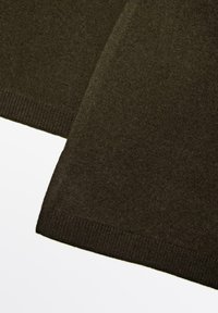 Écharpe en laine vert foncé avec une texture douce, présentant un bord côtelé et une forme rectangulaire simple.