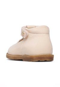 Stivaletto alla caviglia in pelle rosa chiaro con punta rotonda, fascetta in velcro e suola in gomma. Texture liscia con cuciture minime e un piccolo dettaglio dorato.