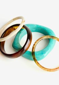 Tri bangles iz gl glossy smole: ena prozorna krema, ena solidna turkizna in ena rjava marmorirana zasnova z zelenimi in oranžnimi akcenti.