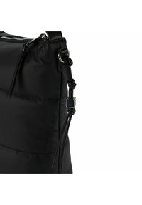 Zwarte puffer tas met een gequilt ontwerp, voorzien van een bovenrits en verstelbare schouderband. Accenten zijn een geknoopte detail en zilverkleurige hardware.