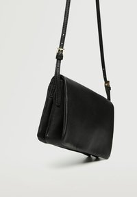 Borsa a tracolla in pelle nera con una superficie liscia, forma rettangolare slanciata e tracolla regolabile con dettaglio in oro.