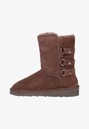 Brune suede ankelstøvle med rund tå, blødt indersidefoder og tre dekorative spænder på siden. Flad sål.