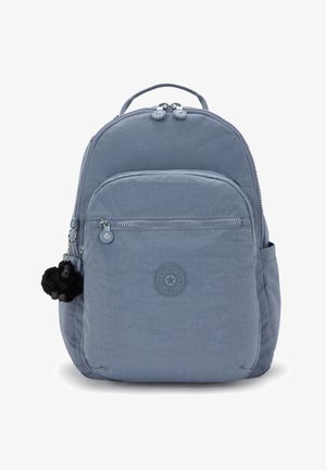 Zaino azzurro chiaro realizzato in tessuto morbido con forma arrotondata. Presenta una tasca anteriore, chiusure a zip e un portachiavi a forma di scimmia nera.