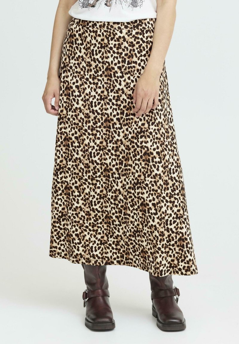 Maxikjol i leopardmönster i beige och brunt, tillverkad av mjukt tyg med ett flytande mönster. Kombinerad med mörkbruna ankelstövlar.