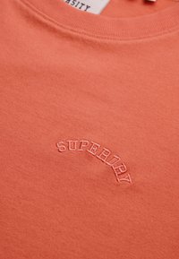 Koraaloranje sweatshirt van zacht katoen, met een ronde halslijn en een gebogen geborduurd "SUPERDRY"-logo in bijpassende draad.