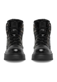 Czarne skórzane botki z futrzanym wykończeniem w okolicy kołnierza, metalowymi pierścieniami D-ring, sznurowanym przodem i grubą, teksturowaną gumową podeszwą.