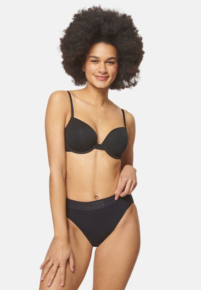 Svart bh med justerbara band och släta kupor, kombinerad med matchande högmidjade svarta trosa. Båda är tillverkade av mjukt tyg, med en minimalistisk design.