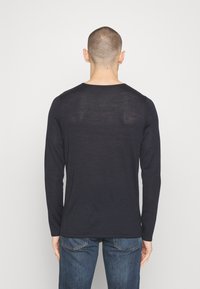 T-shirt a maniche lunghe in navy realizzato in un tessuto morbido e leggero. Presenta un collo tondo e una silhouette aderente. Design semplice, senza motivi o accessori.