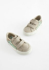 Beige velcro sneakers med strukturerede lysegrønne sideaccenter, der har en tegneseriefigur og hvide gummisåler.