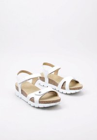Witte sandalen met kurken voetbed en witte rubberen zool. Voorzien van verstelbare banden met een metallic accent en een open teen ontwerp.