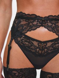 Svart blonde strømpebelte med blomsterdesign, satengremmer og detaljer i gull; gjennomsiktig svart truse med mesh-detaljer.
