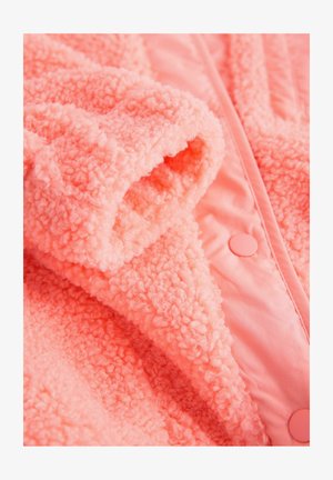 Ružová nadýchaná bunda s jemnou, štruktúrovanou látkou, ktorá má plyšový povrch a hladkú podšívku, navrhnutá so zapínaním na patentky.