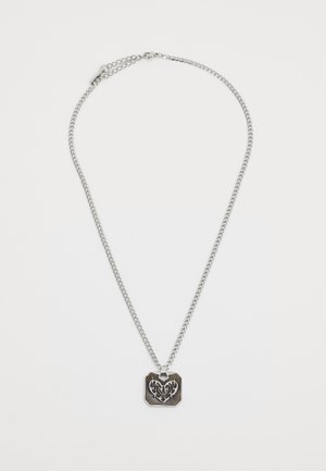 Silver chain necklace with a rectangular pendant featuring an embossed heart design and intricate detailing. Smooth metal texture.