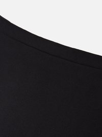 Tessuto nero con una texture liscia e opaca, esposto ad angolo per mostrare il bordo curvo e i dettagli delle cuciture.