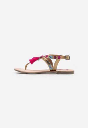 Tan flad sandal med pink kvast, broderede flerfarvede mønstre, tynde remme og ankelspænde lukning på hvid baggrund.